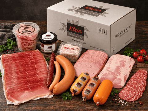 Wurstpaket mit Aufschnitt, Würstchen und Wurst im Glas vor einem Versandkarton