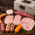 Probierpaket mit Fleischsalat, Würstchen und Aufschnitt vor einem Versandkarton
