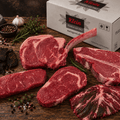 Rindfleischpaket mit Steaks und Tomahawk-Steak vor einem Versandkarton